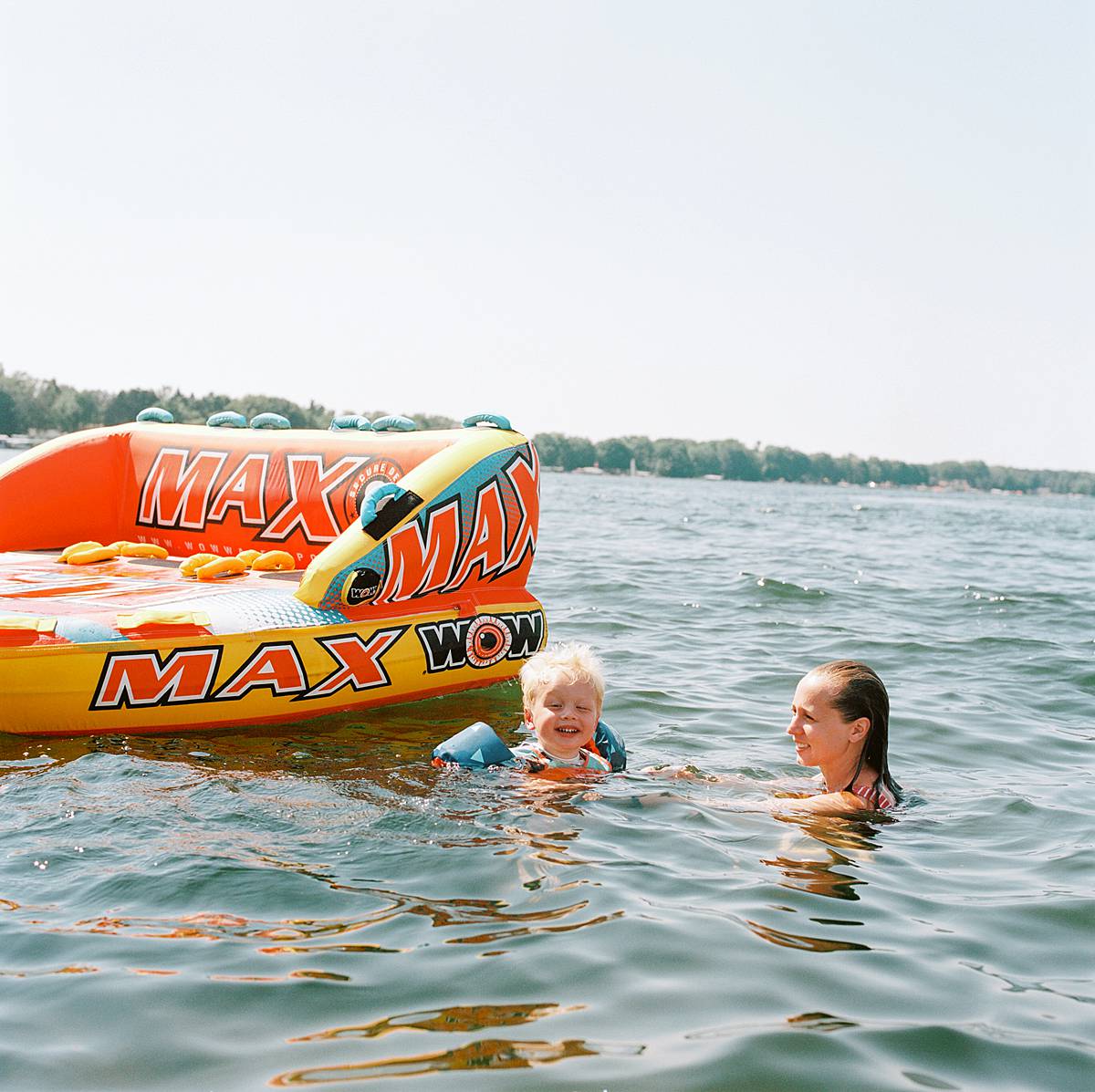 Kodak portra 800 film shot of family in water in northern michigan with giant boat tube